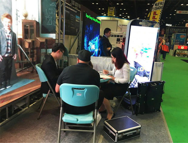 奧蘭多橘城會展中心聯誠發展位現場，外貿部經理黃勇強和何巧玲與意向客戶在交談中